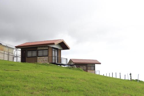 a house on top of a grassy hill at Cabañas La Montañuela in Llano Grande
