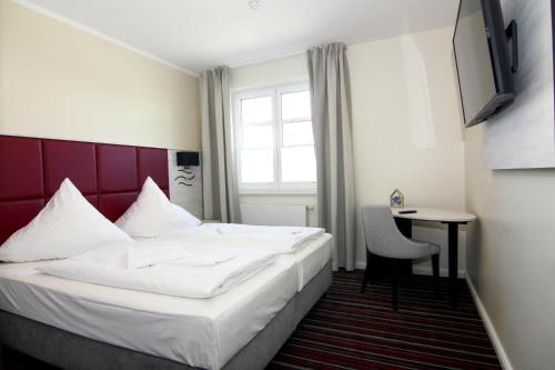 a hotel room with a bed and a table and a window at Appartements im Avalon Hotel Bellevue, Fehmarn in Fehmarn