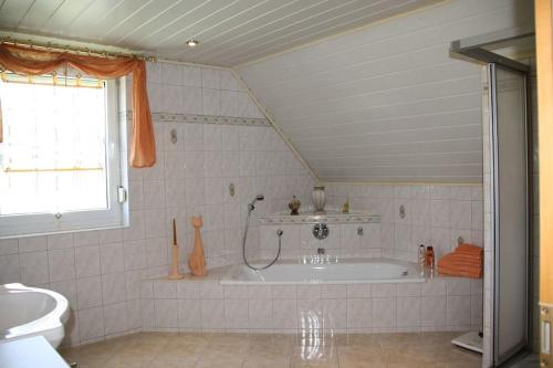een badkamer met een bad en een wastafel bij Ferienhaus Perle am Fuße der Augustusburg in Augustusburg