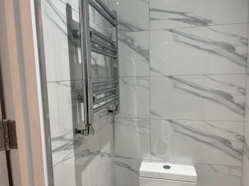 a bathroom with a shower with marble walls at Park View Serviced Apartment - Next to Northolt Tube Station - Near Central London & Wembley in Northolt