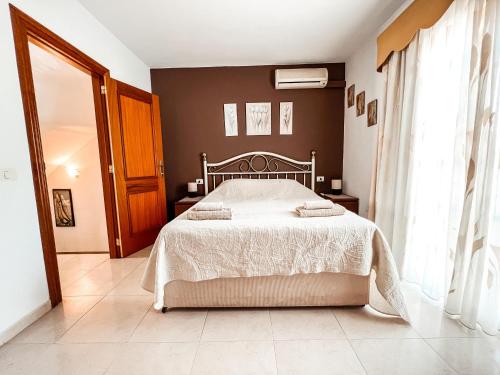1 dormitorio con 1 cama con colcha blanca en Townhouse with sea view Callao Salvaje CS148, en Callao Salvaje