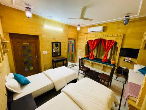 een kamer met 3 bedden en een piano bij Golden Marigold Hotel in Jaisalmer