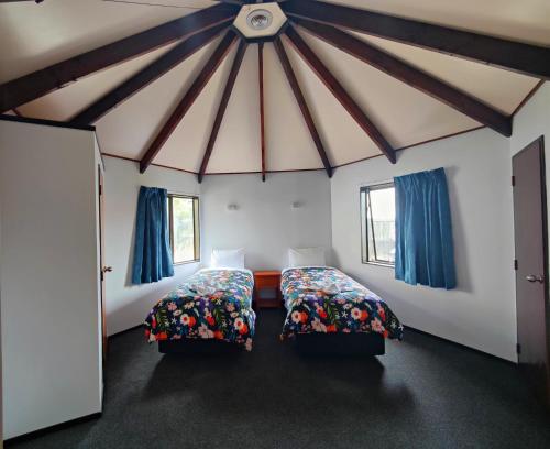 a room with two beds and two windows at Pure Motel in Rotorua