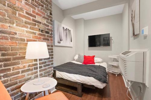 - une chambre avec un lit et un mur en briques dans l'établissement Long Term Studio Stay - German Village Downtown, à Columbus