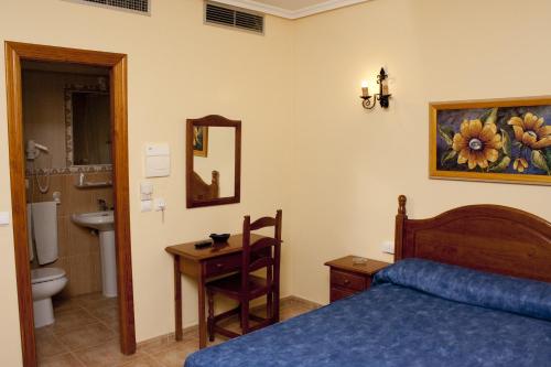 um quarto com uma cama e uma casa de banho com um lavatório em Hotel Rural Miguel Rosi em Huércal-Overa