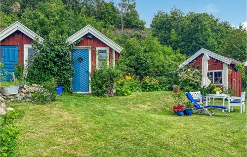 a yard with two sheds and a table and a chair at 4 Bedroom Cozy Home In Ellös in Ellös