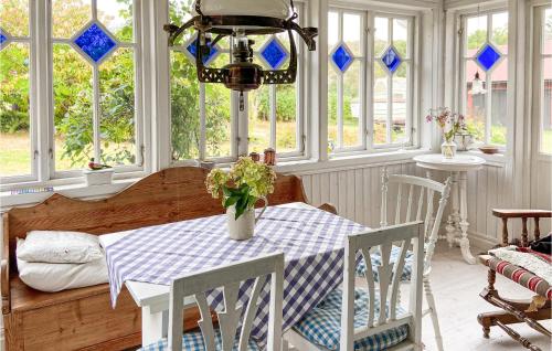 a dining room with a table and chairs and windows at 4 Bedroom Cozy Home In Ellös in Ellös