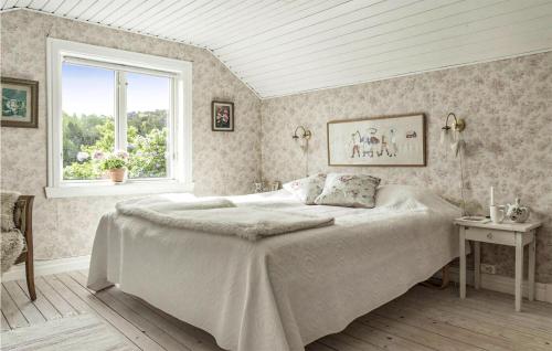 a bedroom with a large bed and a window at 4 Bedroom Cozy Home In Ells in Ellös
