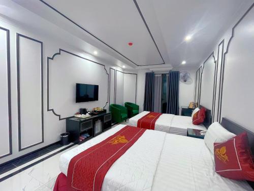 a hotel room with two beds and a television at Rosy Hotel in Hanoi