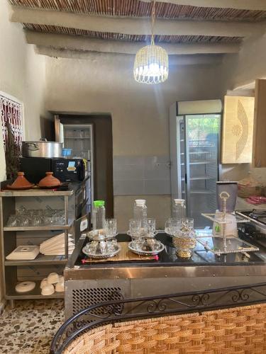 a kitchen with a counter with glasses on it at AUBERGE El HAJ BOUAYYADY ZOUAKINE in Guezira