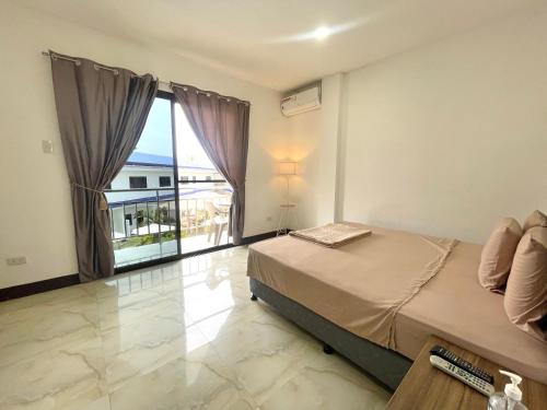 邦勞的住宿－MGH Alona Resort，一间卧室设有一张床和一个大窗户