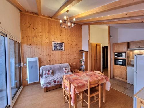 une salle à manger avec une table et une cuisine dans l'établissement Appartement 7 pers avec balcon, wifi, animaux admis, parking - Saint-Michel-de-Chaillol - FR-1-393-88, à Saint-Michel-de-Chaillol