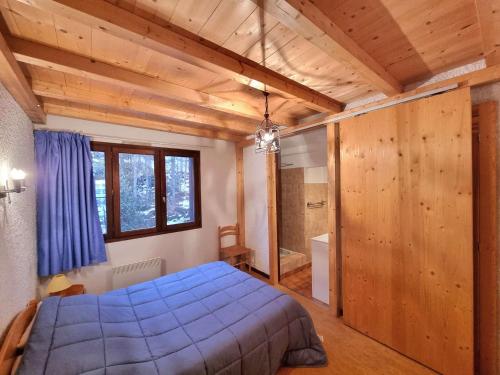 1 dormitorio con cama azul y baño en Appartement Saint-Michel-de-Chaillol, 3 pièces, 7 personnes - FR-1-393-88, en Saint-Michel-de-Chaillol
