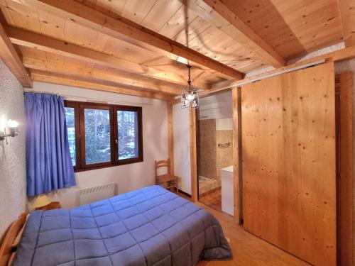 - une chambre avec un lit bleu et une salle de bains dans l'établissement Appartement 7 pers avec balcon, wifi, animaux admis, parking - Saint-Michel-de-Chaillol - FR-1-393-88, à Saint-Michel-de-Chaillol
