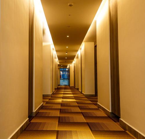 un pasillo de un edificio de oficinas con un pasillo largo en Hotel Galore Inn, en Mysore