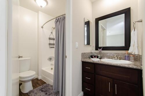 a bathroom with a sink and a toilet and a mirror at Sunset Strip 2 Bedroom 2 Bathroom with Pool & Views in Los Angeles