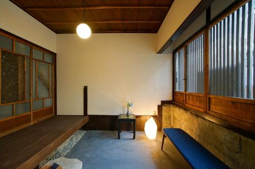 a living room with a blue couch and windows at Nishijinya in Kyoto