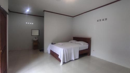 1 dormitorio con 1 cama en una habitación blanca en Kristal Garden en Sekotong