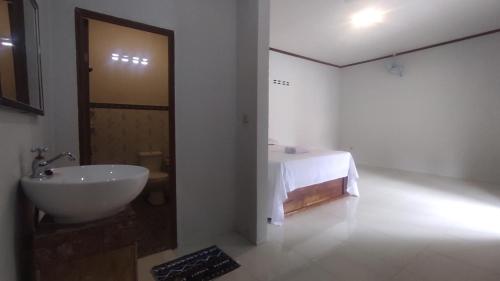 biała łazienka z umywalką i stołem w obiekcie Kristal Garden w mieście Sekotong