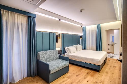 a bedroom with a bed and a chair at CC Palace Hotel in Rome
