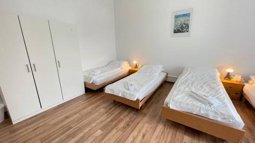 two beds in a small room with wooden floors at Villa Zentrum Haus Davos in Davos