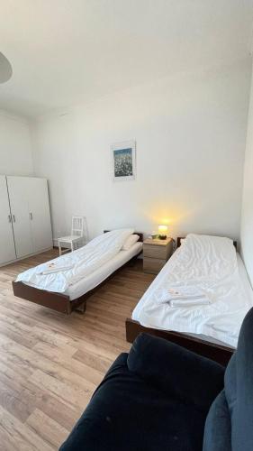 two beds in a room with wooden floors at Villa Zentrum Haus Davos in Davos