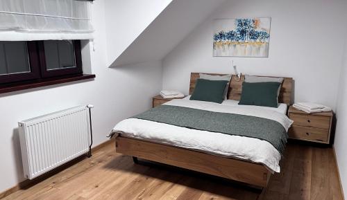 a bedroom with a large bed with green pillows at Apartmán na Pasekách in Bystrzyca