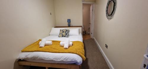 um pequeno quarto com uma cama com um cobertor amarelo em Reed by Paymán Club em Royston
