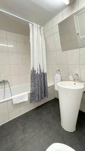 a bathroom with a tub and a toilet and a sink at Villa Zentrum Haus Davos in Davos