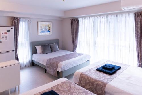 a hotel room with two beds and a window at Japan Hinata Hotel 池下駅 1番出口 徒歩2分 1LDK 50平米 8名 in Nagoya