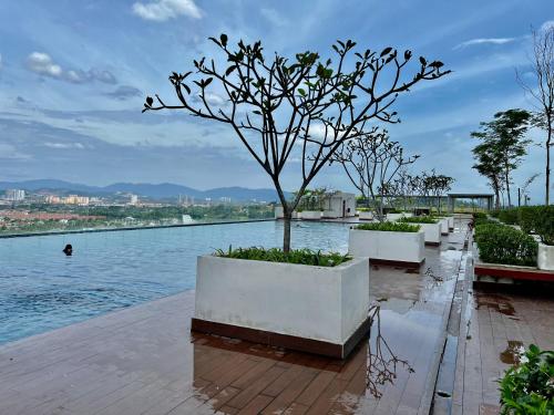 een rij witte planters met een boom naast het water bij Bangi Evo Luxury Suite in Bandar Baru Bangi