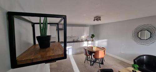 a kitchen with a mirror and a table with a cactus at Maple by Paymán Club in Royston
