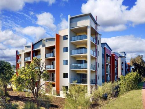 un edificio de apartamentos al lado de un campo en Bright 1 Bedroom Joondalup Stay, en Perth