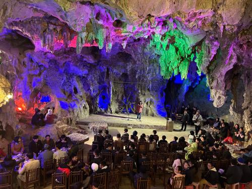 a group of people sitting in chairs in a cave at Yen Nhi Homestay Ban Gioc in Cao Bằng