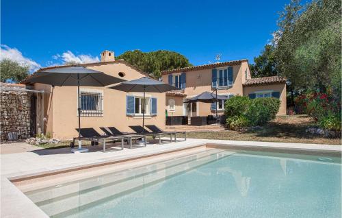 a house with a swimming pool with chairs and umbrellas at Maison Des Rêves in Saint-Cézaire-sur-Siagne