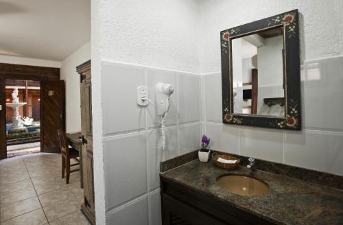 a bathroom with a sink and a mirror on the wall at Quari Quara BY MN Hotéis in Rio das Ostras