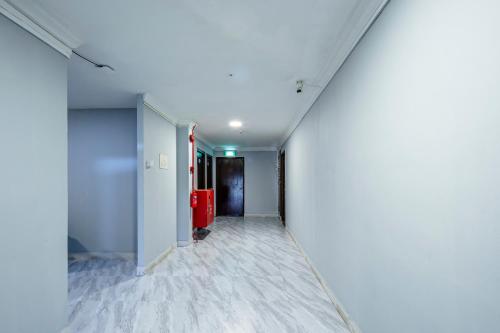 an empty hallway with white walls and a red refrigerator at K Hotel 8 in Singapore