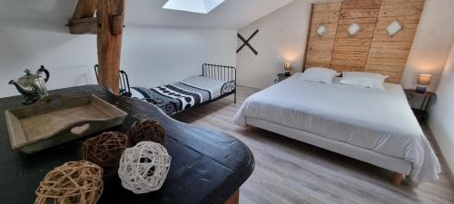 a bedroom with a large bed and a couch at Gîtes à la campagne - La Petite Clavelie in Ribérac