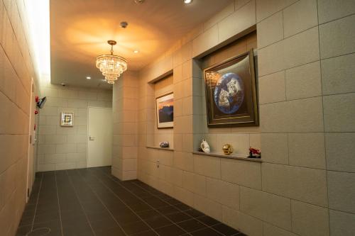 a hallway with a tile wall with a painting on it at Japan Hinata Hotel 池下駅 1番出口 徒歩2分 1LDK 50平米 8名 in Nagoya