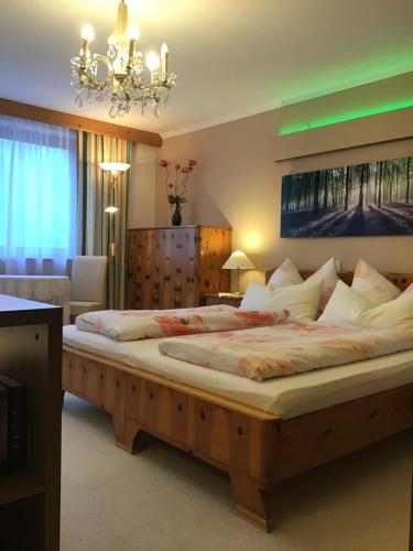 a bedroom with two beds and a chandelier at Alpbach Apartments in Reith im Alpbachtal