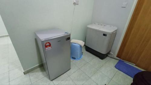 a small refrigerator and a trash can in a room at WK HOMESTAY PASIR MAS in Pasir Mas