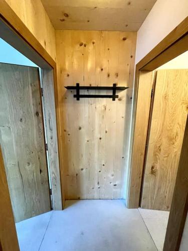 a room with a wooden wall with a shelf on it at New relaxing mountain getaway. in Döllach