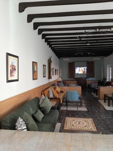 un salon avec un canapé vert et une table dans l'établissement Le relais des sables, à Tatta