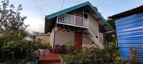 ein Haus mit einem Balkon, Stühlen und Pflanzen in der Unterkunft Townside Lodge in Nuwara Eliya