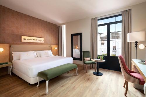 een hotelkamer met een bed, een bureau en een tafel bij Los Seises Sevilla, a Tribute Portfolio Hotel in Sevilla