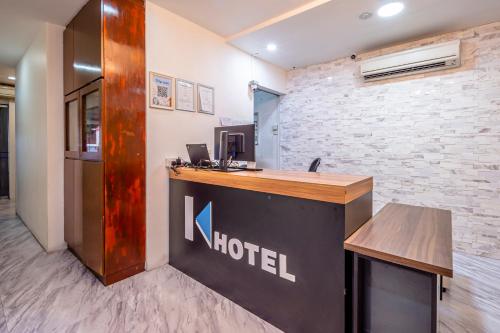 a hotel reception desk in a room with a brick wall at K Hotel 1515 in Singapore