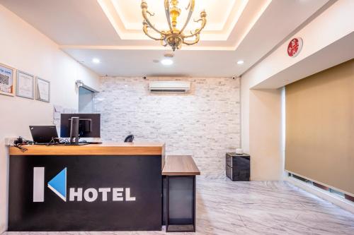 a hotel lobby with a reception desk and a chandelier at K Hotel 1515 in Singapore