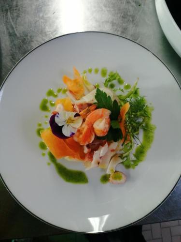 a white plate with a dish of food on a table at Hotel Riposo in Gatteo a Mare