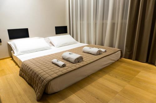 a bedroom with a bed with two pillows on it at ZOE LUXURY SUITES in Catania