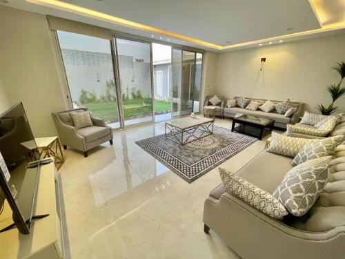 a large living room with couches and a tv at شاليه الماسيه خاص و مميز بأحدث المواصفات لنصنع الجمال بعينه in Riyadh